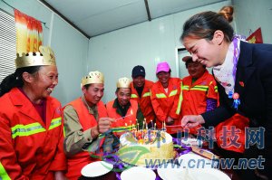 社區(qū)工作人員為集體過生日的三名環(huán)衛(wèi)工人點上生日蠟燭。 本報通訊員 趙松 攝