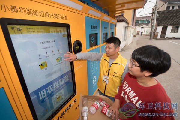 10月30日，在道場(chǎng)鄉(xiāng)錢(qián)山下村，工作人員（左）指導(dǎo)村民在智能回收機(jī)上進(jìn)行垃圾分類(lèi)回收。
